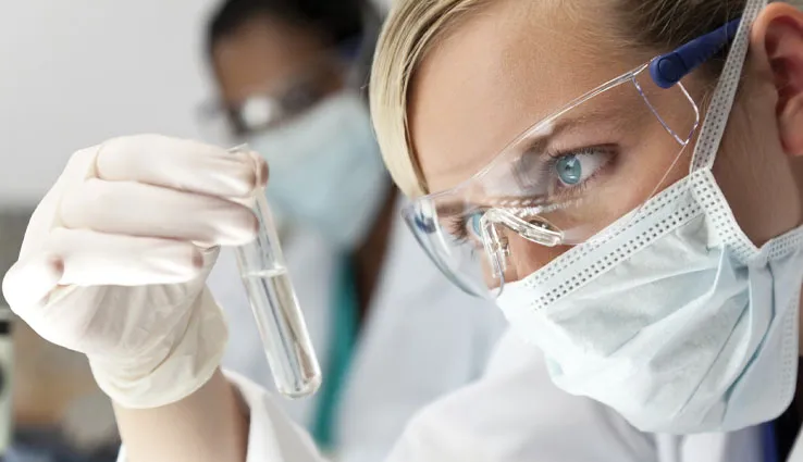 Scientist reviewing a clear skincare product in a test tube.