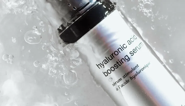 A bottle of PCA SKIN Hyaluronic Acid Boosting Serum resting in clear water.