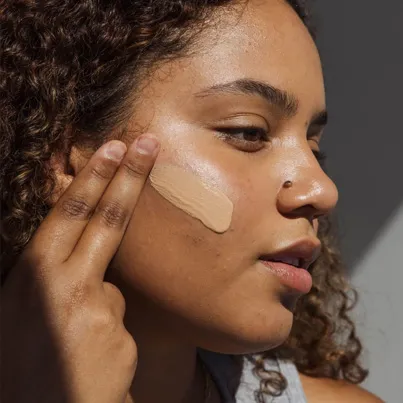 Women applying Sheer Tint SPF